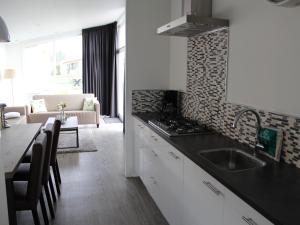 a kitchen with a sink and a living room at Charming Retreat for Your Escape in Bemelen