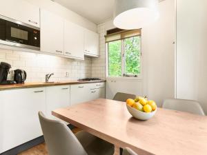 a kitchen with a wooden table with a bowl of fruit on it at Cozy Forest Retreat Near Putten in Putten