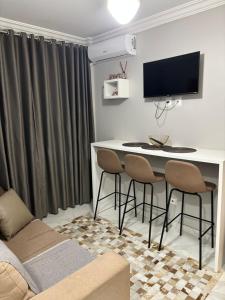 a living room with a table with chairs and a tv at Apto 1 dorm - San Francisco - localização perfeita in Balneário Camboriú