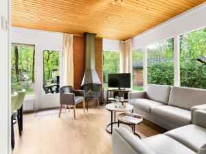 ein Wohnzimmer mit Sofa und Fernseher in der Unterkunft Bungalow in Putten near Veluwe Nature Park in Putten