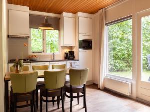 eine Küche mit Tisch und Stühlen und einem Fenster in der Unterkunft Bungalow in Putten near Veluwe Nature Park in Putten