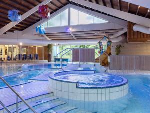 ein großes Schwimmbecken mit Rutsche in einem Gebäude in der Unterkunft Bungalow in Putten near Veluwe Nature Park in Putten
