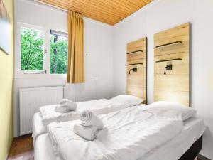 zwei weiße Betten in einem Zimmer mit zwei Fenstern in der Unterkunft Bungalow in Putten near Veluwe Nature Park in Putten + 18 Fotos