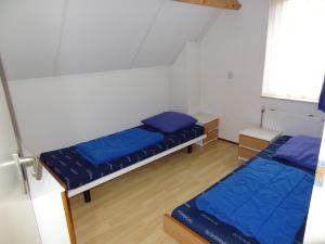 two beds in a small room with blue pillows at Home sauna near beaches of Wemeldinge in Wemeldinge
