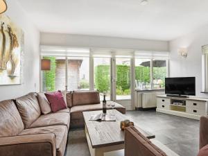a living room with a couch and a tv at Holiday Home in Brouwershaven by Grevelingenmeer in Brouwershaven
