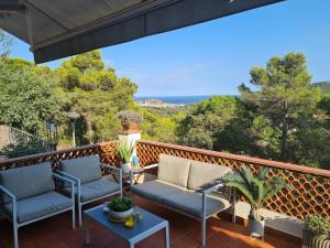 eine Terrasse mit zwei Stühlen und einem Tisch auf einem Balkon in der Unterkunft Villa in Sant Feliu with Private Pool in Sant Feliu de Guixols