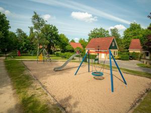 a playground with a slide in the sand at Holiday Home in Brabant with Hot Tub & Sauna 