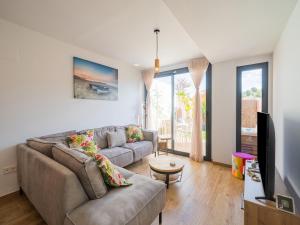 Una sala de estar con un sofá y un televisor. en Villajoyosa Home with Shared Pool, en Villajoyosa