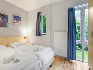 two beds in a room with two windows at Holiday Home near Grevelingenmeer Lake in Brouwershaven +24 photos