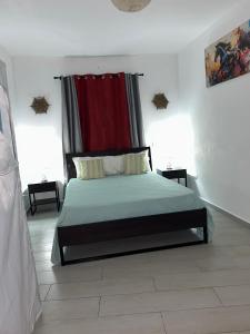 a bedroom with a bed with a red curtain at Villa Kate in Las Terrenas