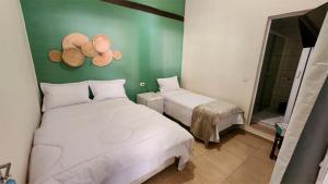a bedroom with two beds and two hats on the wall at Pousada Numar Maresias in Maresias