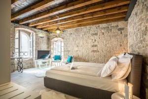 una camera con un grande letto in un muro di mattoni di Bella Notte Di Spalato a Spalato (Split)