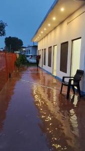 Un banco sentado en una acera mojada al lado de un edificio. en Ramansh Home stay, en Ayodhya