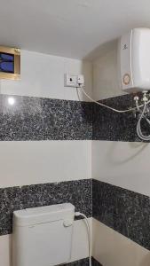 baño con aseo y dispensador de papel en la pared en Ramansh Home stay, en Ayodhya