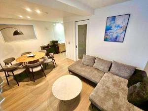 a living room with a couch and a table at 希少新築 家族 グループ歓迎 国際通り近く 4泊以上10offキャンペーン中 in Naha