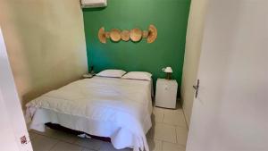 a bedroom with a bed and a green wall at Pousada Numar Maresias in Maresias