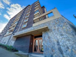 a tall building with a stone wall at HOM I Depto con parking incluido 1D1B in Puerto Varas
