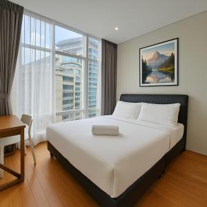 a bedroom with a large bed and a large window at Sky Suites KLCC - Luxury Service Apartments Near Petronas Twin Tower in Kuala Lumpur