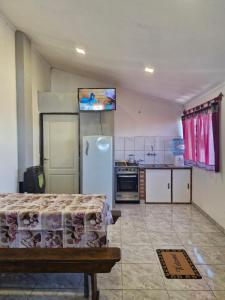una cocina con refrigerador y estufa en Hospedaje El Quincho2, en Gobernador Gregores