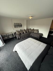 a bedroom with a large bed and a couch at Convenient Affordable Hospital Stay in Tauranga