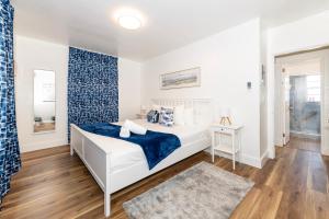 una camera con un letto bianco e una parete blu di South Beach Apartments a Miami Beach