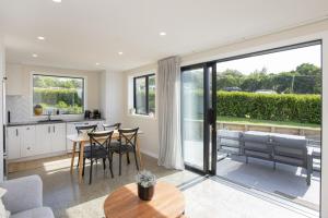 a kitchen and living room with a table and chairs at Brand New Unit only 4 km to Gisborne CBD in Gisborne +19 photos