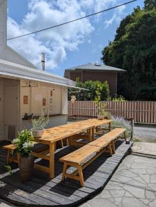 a wooden picnic table and benches on a patio at The Surf Lodge White Beach in Shimoda