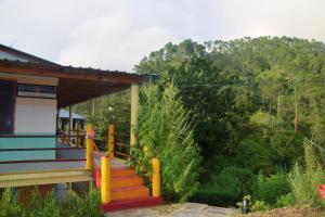 a house with a staircase leading to a porch at The Himalayan Heaven Homestay, Binsar in Binsar