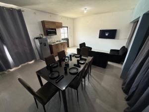 a living room with a table and chairs and a kitchen at Loft Cinema Alfredo Mochileando in Tamiahua