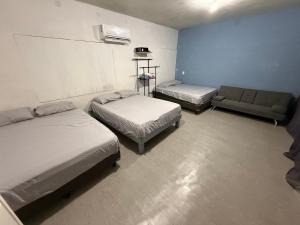 a room with two beds and a couch in it at Loft Cinema Alfredo Mochileando in Tamiahua