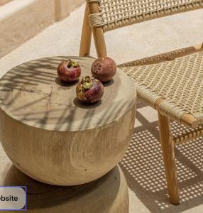 three donuts sitting on a wooden bowl on a chair at Teddies in Ahangama