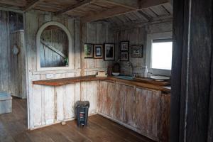a room with wooden walls and a counter with a window at Cabaña Peñones in Murillo