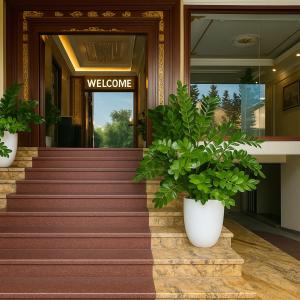 a welcome sign on the door of a building with plants at 希岸三好酒店 in Kon Rung (1)