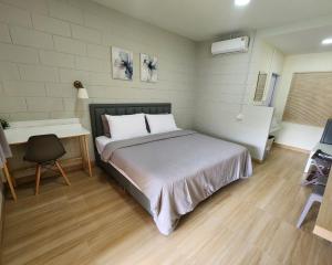 a bedroom with a bed and a desk and a bed sidx sidx sidx at 78's Hometel Pattaya 101 in Pattaya Central