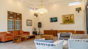 a living room with furniture and a chandelier at HOTEL & WISMA BINTANG JADAYAT in Bogor