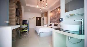 a bedroom with a bed and a sink in a room at The Linux Garden Hotel (City Amphur Muang Yala) in Yala