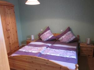 - une chambre avec un lit doté de draps et d'oreillers violets dans l'établissement Gästehaus Jüngling, à Kottenborn