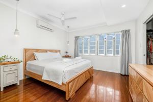 a bedroom with a bed and a window at Spacious Queenslander Retreat in Belgian Gardens