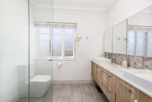 a bathroom with a sink and a toilet and a mirror at Spacious Queenslander Retreat in Belgian Gardens +17 photos