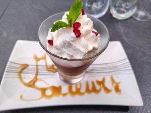ein Dessert im Glas auf einem Teller auf einem Tisch in der Unterkunft MillSaveurs in Dinan