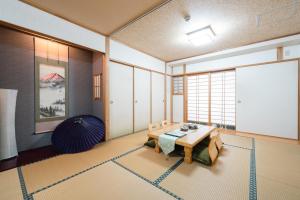 ein Wohnzimmer mit Tisch und großem Fenster in der Unterkunft 瓦の灯 in Takamatsu