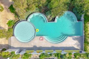 an overhead view of a swimming pool with a tennis racket at cara cara resort in Ko Larn