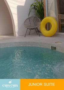 ein Schwimmbecken mit einem Stuhl und einer gelben Gummirutsche in der Unterkunft cara cara resort in Ko Larn + 4 Fotos
