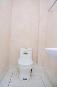 a bathroom with a white toilet and a sink at S - Tetu Inn Nairobi CBD in Nairobi +35 photos