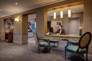 a woman sitting at a desk in a hotel lobby at Hotel Muguet in Paris