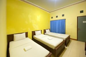 Postel nebo postele na pokoji v ubytování Wisma Kartini Syariah near Alun Alun Sidoarjo RedPartner + 18 fotografií