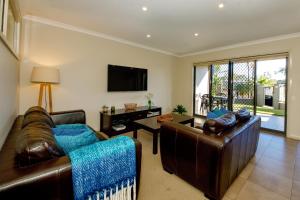 a living room with two leather couches and a television at 39C Cypress in Mulwala