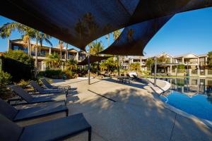 a swimming pool with lounge chairs next to a resort at 39C Cypress in Mulwala