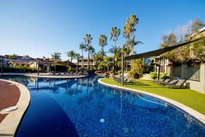 a swimming pool at a resort with palm trees at 39C Cypress in Mulwala