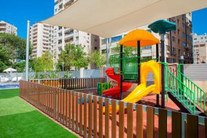 a playground with a slide and an umbrella at Odysseia Hotel Kapetanios in Limassol